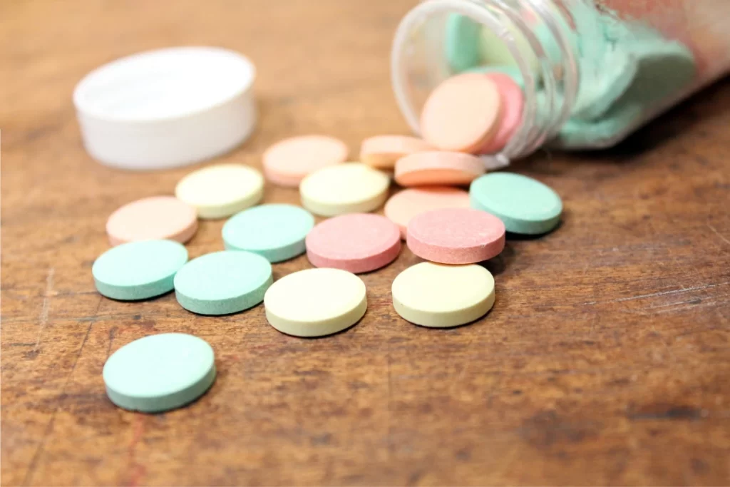 chewable tablets coming out from glass vial.