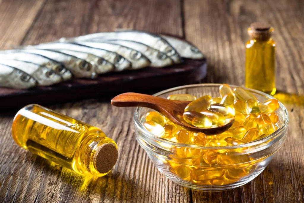 Fish Oil capsules on wooden black ground.