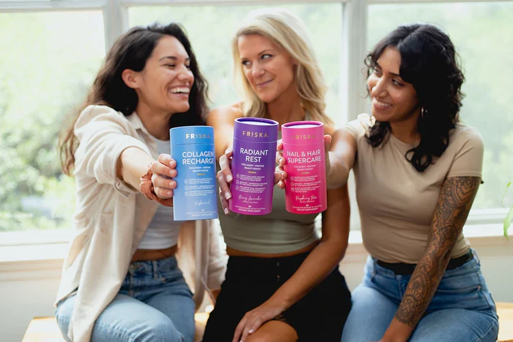 3 Girls showing friska probiotics supplements in their hands. 