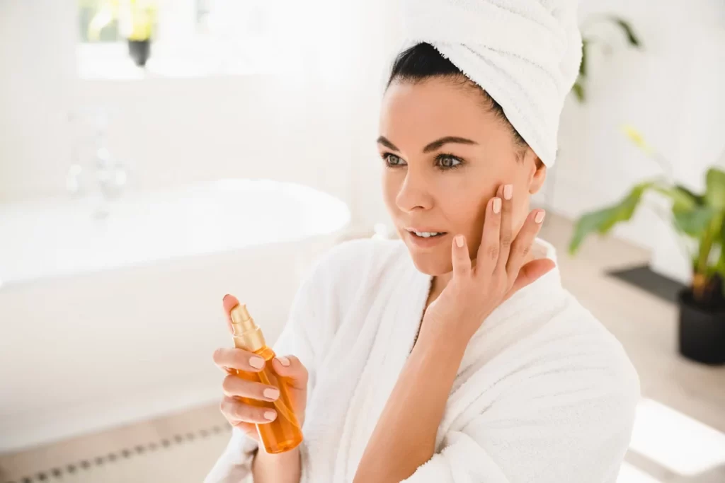 Women applying spray for healthy skin. 