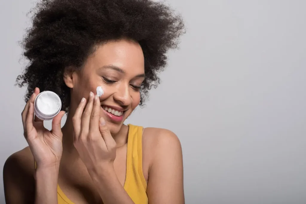 A lady using face cream. 